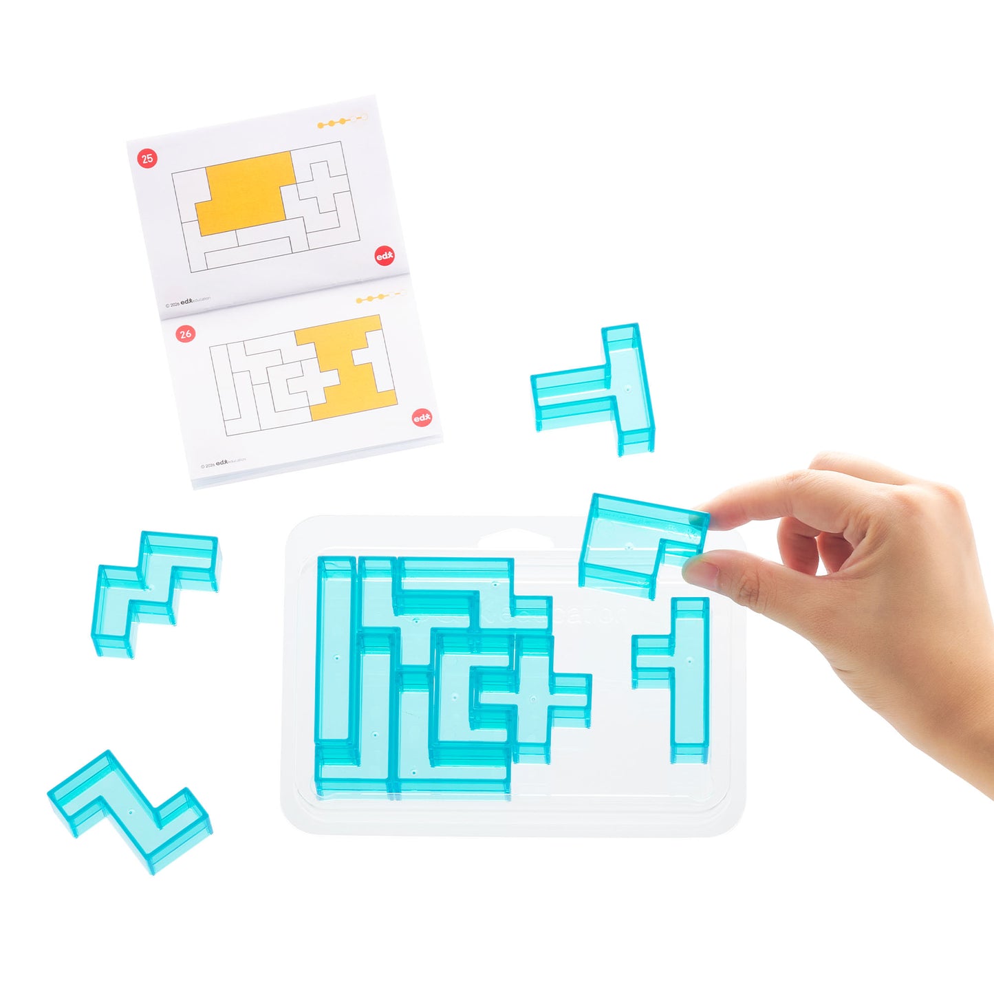 A hand placing a translucent blue L-shaped tile into a white tray of matching maze-solving tiles, with two printed instruction sheets shown on a white background.