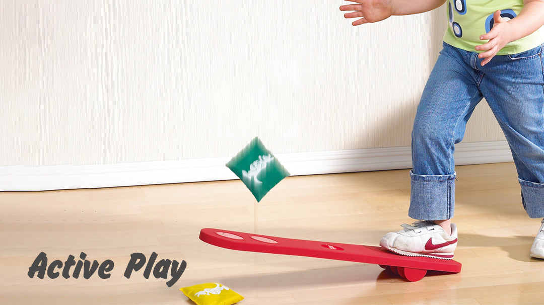 Child using the Joey Jump toy to launch a bean bag into the air, demonstrating balance, coordination, and gross motor skills development.
