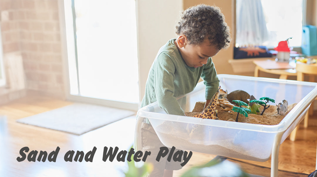 Young child engaged in sand and water play using animal figurines and props in a sensory bin. Text overlay reads 'Sand and Water Play'.